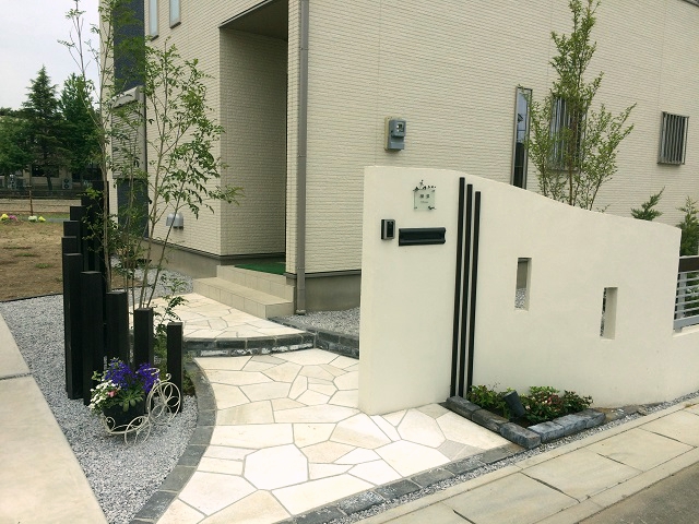 羽生市　ライティングで浮かび上がる白い塗り壁と乱形石のアプローチが幻想的な外構