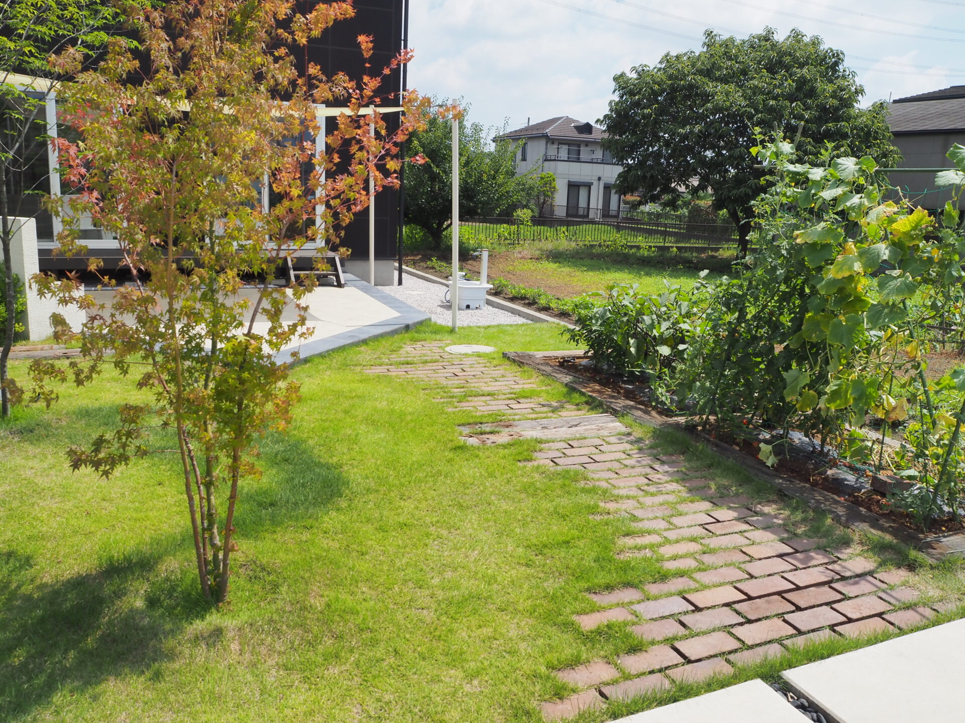 東松山市のシックなデコレーションウォールと鮮やかなシェードセイル高級感のある外構のお庭まわり