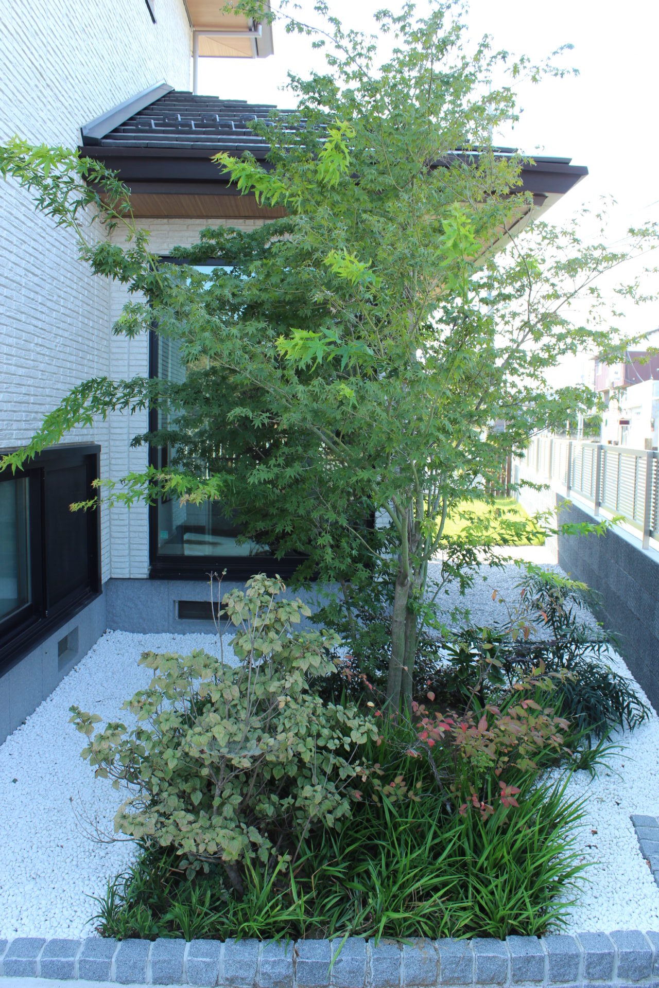 深谷市のスリットの入った白い大きな門柱が印象的な建物のバランスが美しいオープン外構の坪庭