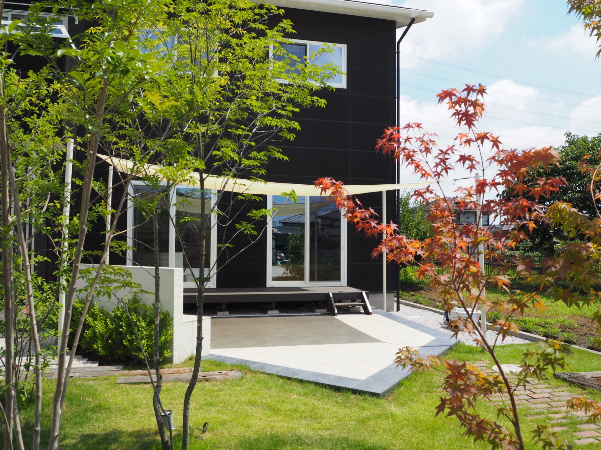 東松山市のシックなデコレーションウォールと鮮やかなシェードセイル高級感のある外構のお庭別角度
