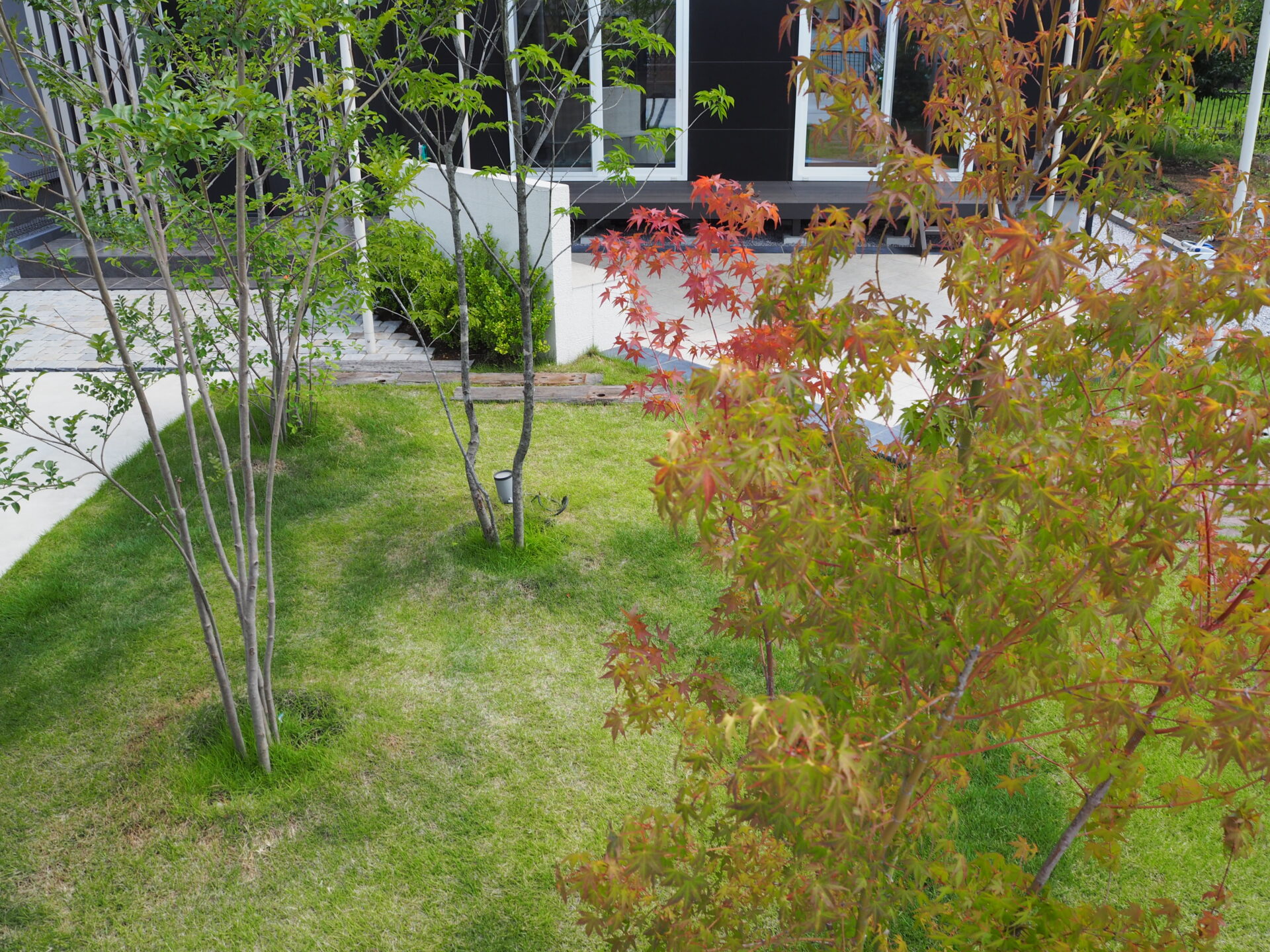 東松山市のシックなデコレーションウォールと鮮やかなシェードセイル高級感のある外構の植栽